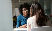 Deux femmes assises à une table discutent