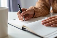 Mains en train d'écrire dans un carnet