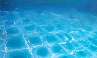 Ausschnitt eines Kunstwerks mit Lichtreflektionen unter Wasser