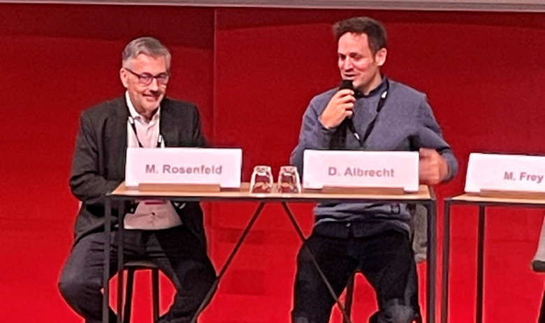 Interview Swiss Brain Health Plan Martin D. Rosenfeld und Daniel Albrecht sitzen am Podium. Daniel Albrecht hält ein Mikrofon in der Hand.