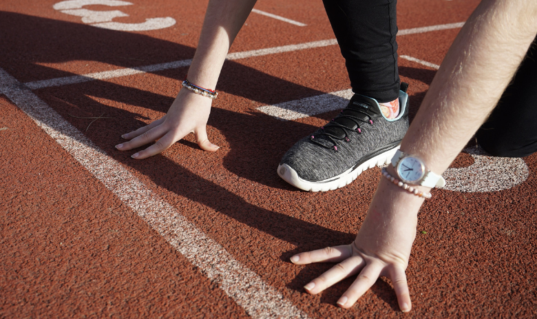 Gewinnspiel Spendenlauf Eine Person steht startbereit an der Startlinie.