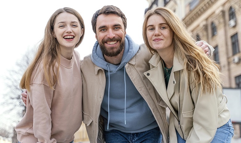 Jeunes Deux femmes et un homme se tenant les uns à côtés des autres