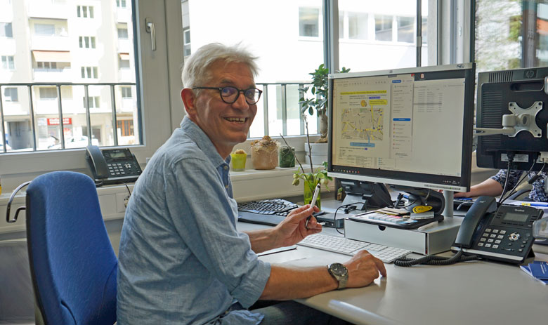 Arbeit Ein Mann sitzt an einem Schreibtisch und lächelt