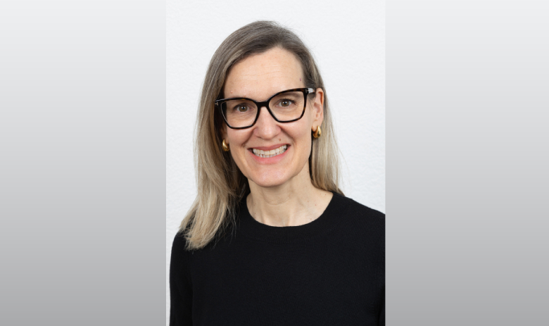 Fachinterview Portraitfoto einer Frau mit blonden Haaren und Brille. Sie trägt einen schwarzen Pullover und lächelt in die Kamera.